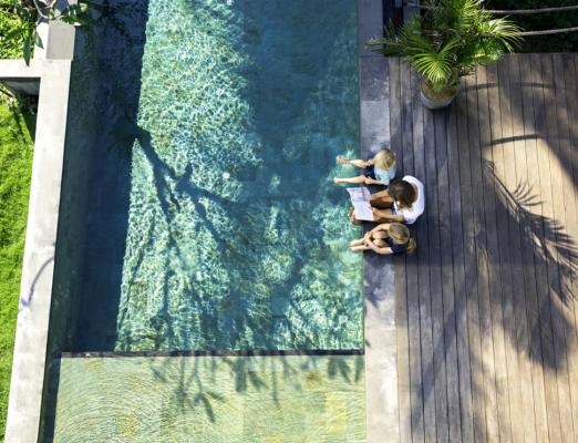 Kid and parent are hanging out near swimming pool